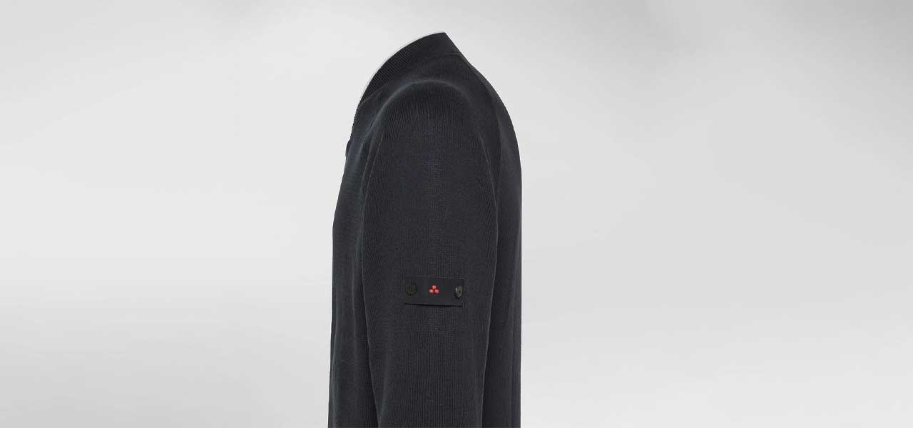 Detail van het Peuterey zip-vest uit de collectie 2025, met iconisch logo op de mouw. Verkrijgbaar bij Van den Broek Herenmode in Haarlem.