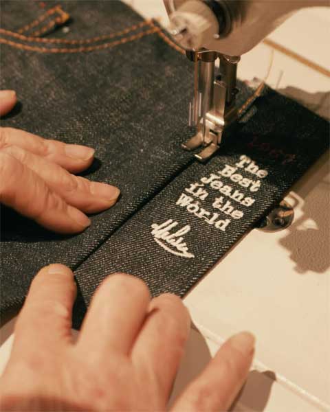 Close-up van een Tramarossa jeans met de kenmerkende borduurtekst "The Best Jeans in the World", symbool voor Italiaans vakmanschap en exclusiviteit.