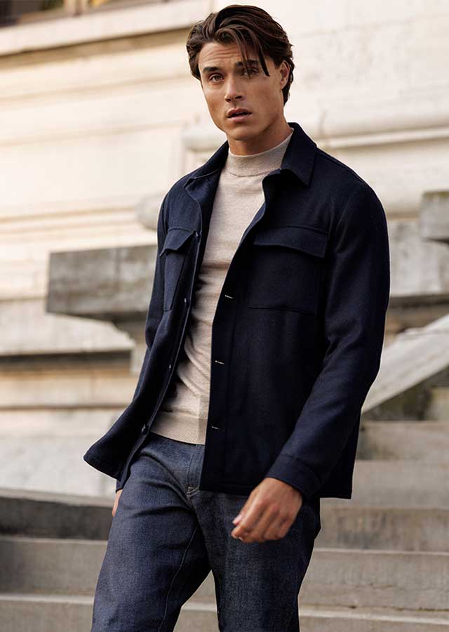 Thomas Maine Navy Overshirt – Van den Broek Herenmode Haarlem Man draagt navy Thomas Maine overshirt met lichte knit, gefotografeerd voor Van den Broek Herenmode in Haarlem.
